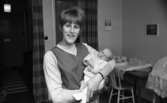 Hälsolivs, Vräktes 27 oktober 1967

I en lägenhet står en kvinna och håller en baby i famnen.