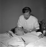 Poliosjuka får hjälp av anhöriga.
23 juli 1955.