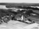 Flygfoto över Svennevad, kyrkan, bostadshus och byggnader.
Bilden tagen för vykort.