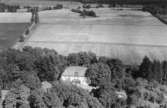 Flygfoto över Skoftesta, Kräcklinge, bostadshus och ekonomibyggnader.
Bilden tagen för vykort.