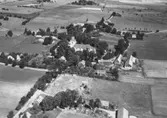 Flygfoto över Tysslinge kyrka, bostadshus och ekonomibyggnader.
Bilden tagen för vykort.
