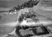 Flygfoto över Stora Mellösa, kyrkan och bostadshus.