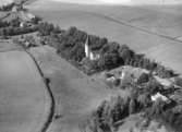 Flygfoto över Hardemo, kyrkan och bostadshus.
Bilden tagen för vykort.