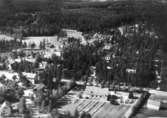 Flygfoto över Mullhyttemo, kyrkan och bostadshus.
Bilden tagen för vykort.