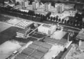 Flygfoto över Hallsberg, bostadshus och byggnader, bl.a. Alléskolans avdelning för verkstadsteknik.