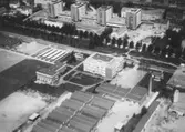 Flygfoto över Hallsberg, bostadshus och byggnader, bl.a. Alléskolans avdelning för verkstadsteknik.