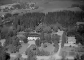 Flygfoto över Åmmebergs Herrgård, tvåvånings herrgårdsbyggnad och flygelbyggnader.