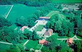 Flygfoto över Säbylunds Herrgård, tvåvånings herrgårdsbyggnad och flygelbyggnader.