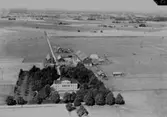 Flygfoto över Älgskogens (Elgskogens) gård, bostadshus och ekonomibyggnader.