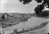 Sågverk, byggnader, båtar.
Norsholm, innanför bro och sluss.