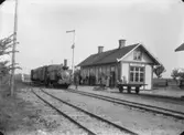 Svennevad station med ett ånglok och järnvägspersonal.