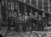 Elva arbetare vid sågverket.