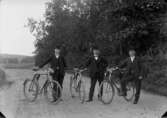 Tre män med cyklar.