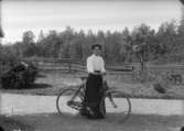 En kvinna med cykel.