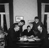 Rumsinteriör, grupp fem män.
Bilreparatörernas styrelse.