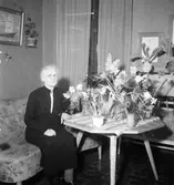 Rumsinteriör, en kvinna, högtid.
Åke Andersson (beställare).