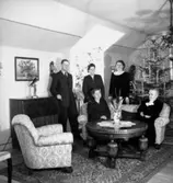 Rumsinteriör, släktgrupp fem personer, högtid.
Falk