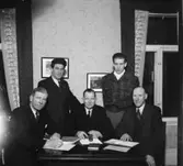 Rumsinteriör, grupp fem män.
Bilreparatörernas styrelse.