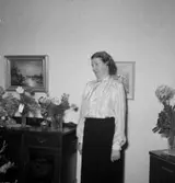 Rumsinteriör, en kvinna, högtid.
Olsson