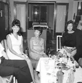 Rumsinteriör, grupp tre kvinnor.
Carlssons födelsedag.