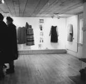 Klädutställning i Wadköping, interiör av utställningssalen, två kvinnor.