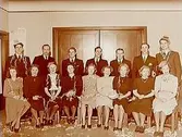 Gruppbild, 16 personer, högtid.
Interiör.