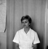 En kvinna (sjuksköterska), bröstbild.
Bilden tagen för pass.