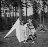 Två lekande barn vid tälten.
Oscaria (beställare ?)