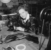 Oscaria Skofabrik, interiör, skotillverkning, en kvinna vid symaskinen.
Bilden tagen för broschyr.