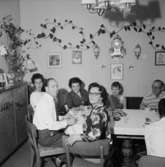 Rumsinteriör, familjegrupp vid bordet.Jönsson