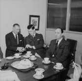 Interiör, tre män vid bordet, högtid.
Wigrell & Co.