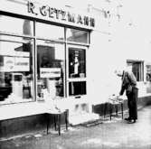 R. Getzmann bensinstation, exteriör, en man.