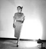 En kvinna.
Damkonfektion från Konsum.