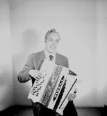 En man med musikinstrument (dragspel).
Wizell