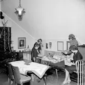 Rumsinteriör, familjegrupp fyra personer, julklappsöppning.