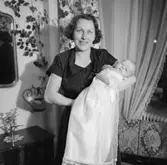 Rumsinteriör, familjegrupp två personer, barndop.
Rulle Molin (beställare).