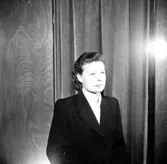 En kvinna.
Kläder från Jörnstedts damekipering.