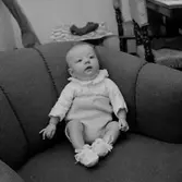 Rumsinteriör, en baby i soffan.
Patrik