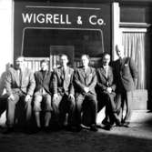 Grupp sex män, personalen.Byggnad i bakgrunden.Wigrell & Co.