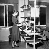 Kontorsinteriör, en kvinna.
Wigrell & Co, utställning på Idrottshuset.