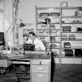 Verkstadsinteriör, en man.
Original Adhner, skrivmaskiner.