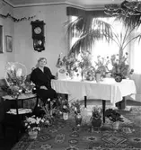 Rumsinteriör, en kvinna.
Fru Olga Andersson på 60-årsdagen.