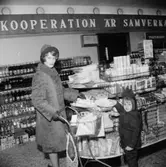 Konsum, affärsinteriör, en kvinna och en liten flicka.