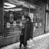 Konsum, exteriör, skyltfönster.En kvinna och en liten flicka.