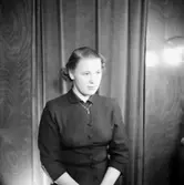 En kvinna.
Kläder från Jörnstedts damekipering.