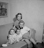 Rumsinteriör, fyra barn i soffan.Fru Blomberg