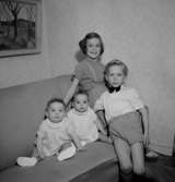 Rumsinteriör, fyra barn i soffan.Fru Blomberg