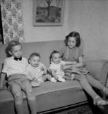 Rumsinteriör, fyra barn i soffan.Fru Blomberg