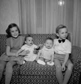 Rumsinteriör, fyra barn i soffan.Fru Blomberg