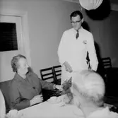 Rumsinteriör, grupp vid bordet, Kexens pensionärer. Personalklubben uppvaktar.
Örebro Kexfabrik.